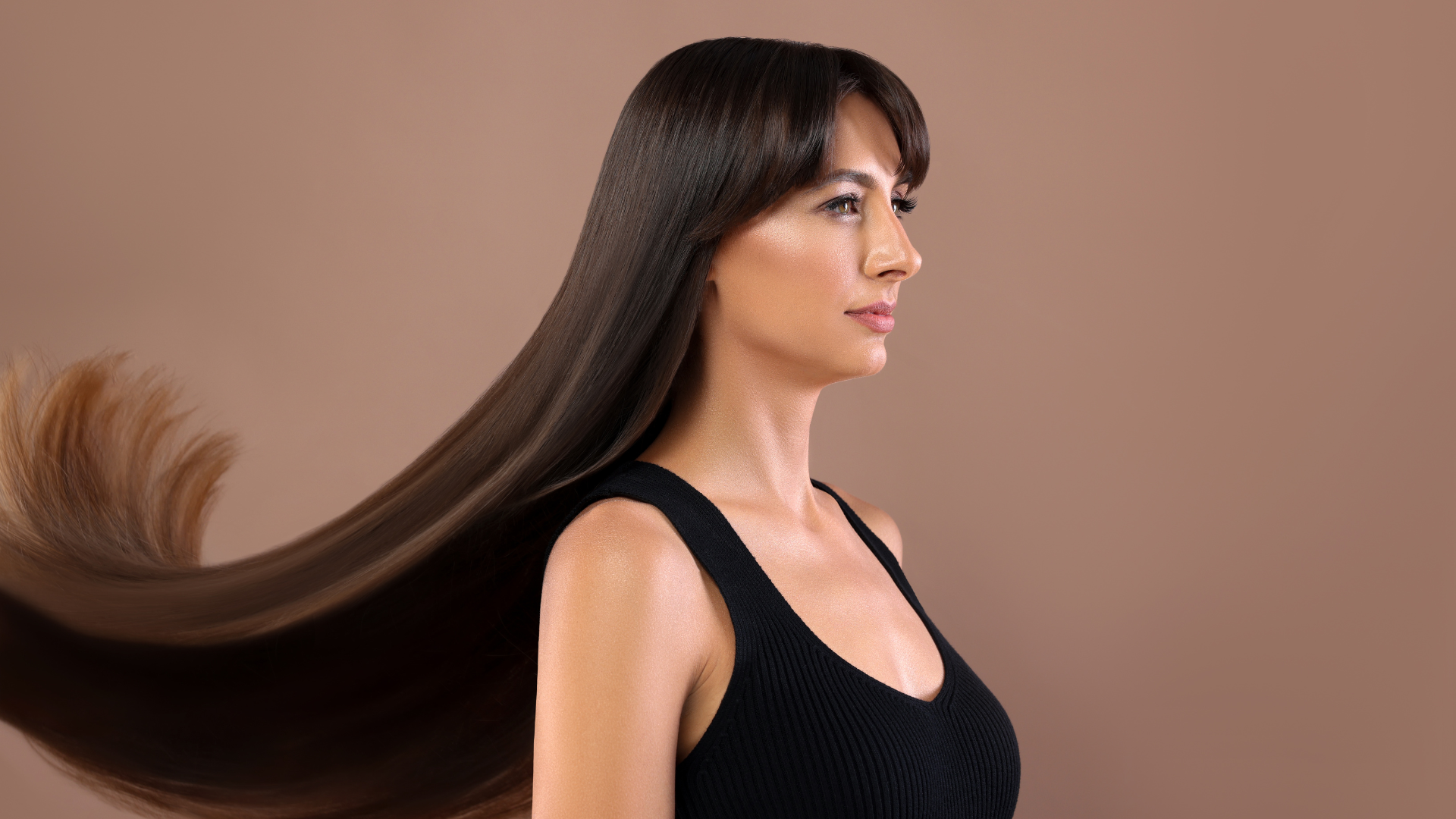 Woman with long, shiny hair showcasing natural radiance and smooth texture.
