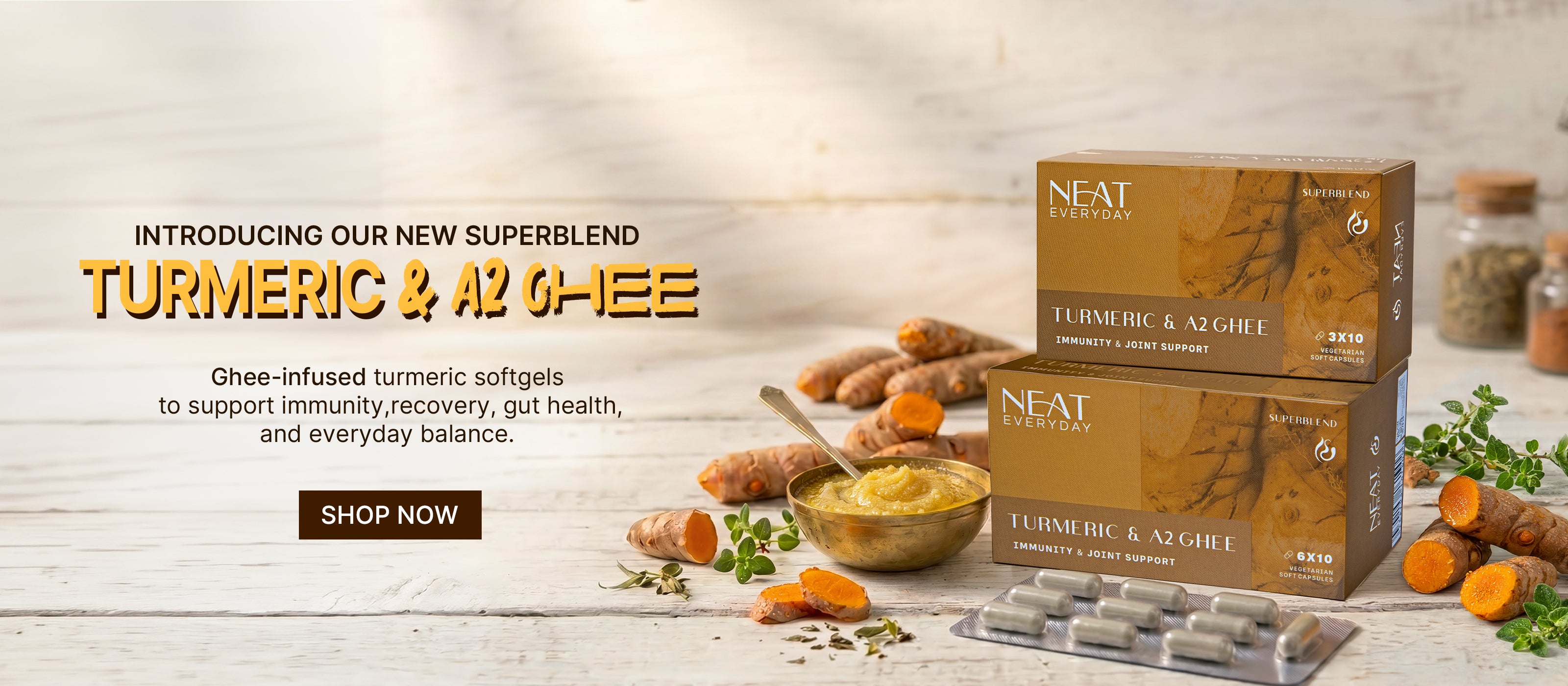 NEAT Turmeric & A2 Ghee product packaging with turmeric roots and ghee on a wooden surface.