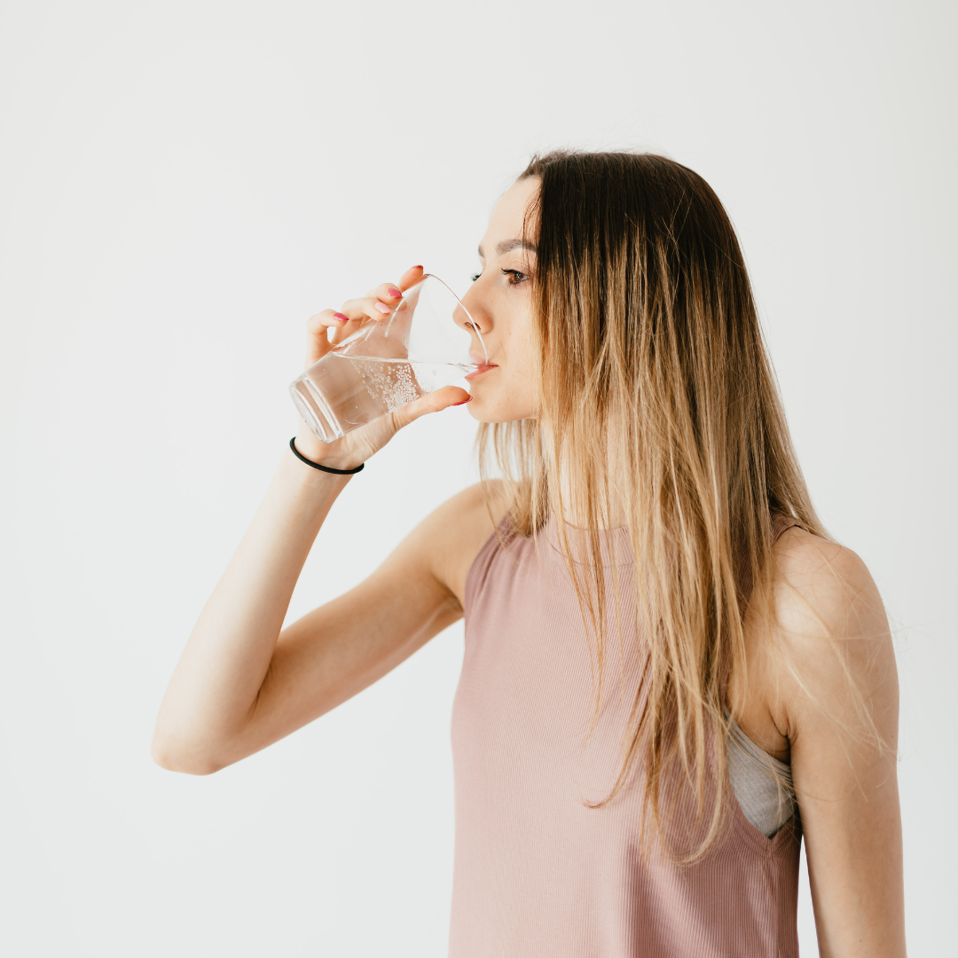 Woman practicing Ayurvedic routine by drinking warm water in morning